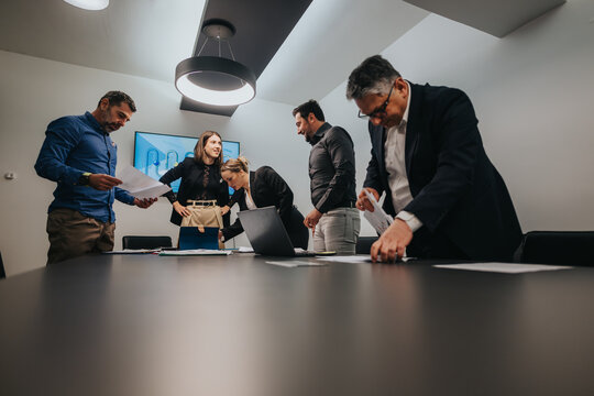 Professionals discussing data and ideas during a collaborative meeting in a contemporary office. - Powered by Adobe