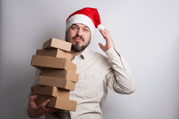 Happy man in santa hat holding stack of delivery boxes