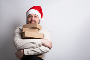 Happy man in santa hat holding stack of delivery boxes