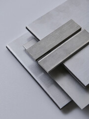 High quality close up image of stainless steel metal bars and flat sections with smooth industrial texture, suitable for construction, engineering, manufacturing, and industrial design concepts.