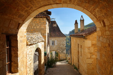 The village Castelnaud, Dordogne, France, located on a hill, with traditional medieval houses (with sloping slate roofs) and arcades