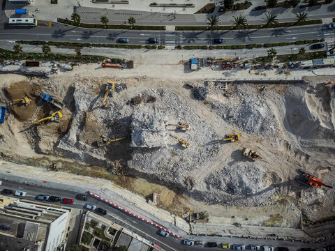 Aerial view of construction site excavators clawing at the earth, contrasting with the urban landscape, creating a scene of transformation, Split, Split-Dalmatia County, Croatia.