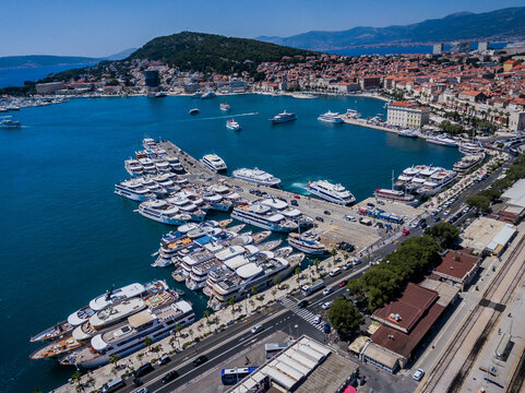 Aerial view of a vibrant harbor where sleek yachts contrast with the ancient architecture along the waterfront, Split, Split-Dalmatia County, Croatia.
