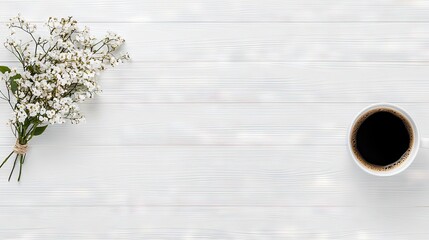 A simple, elegant flat lay composition featuring a bunch of small white flowers and a mug of coffee on a white wooden background.