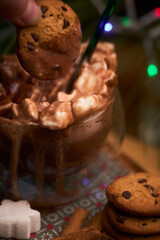 Hand Dipping Cookie into Hot Chocolate with Marshmallows