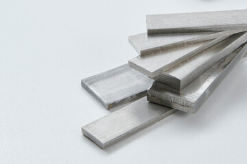 High quality close up image of stainless steel metal bars and flat sections with smooth industrial texture, suitable for construction, engineering, manufacturing, and industrial design concepts.