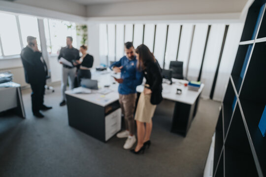 Group of colleagues working and discussing ideas in a contemporary office setting, fostering teamwork and cooperation in a corporate environment.