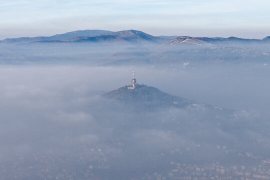 Aerial view of a lone tower piercing through a sea of ethereal fog, standing sentinel above the city, Sarajevo, Federation of Bosnia and Herzegovina, Bosnia and Herzegovina.