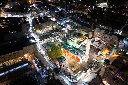 Aerial view of the Gazi Husrev-beg Mosque glowing warmly amidst the dark cityscape, a beacon of light in the heart of Sarajevo, Federation of Bosnia and Herzegovina, Bosnia and Herzegovina.