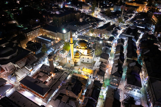Aerial view of the illuminated Gazi Husrev-beg Mosque standing majestically amidst the maze of streets and buildings at night, Sarajevo, Federation of Bosnia and Herzegovina, Bosnia and Herzegovina.