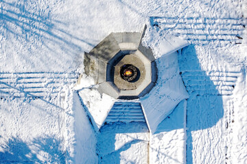 Aerial view of eternal flame monument surrounded by pristine snow, casting long shadows in the winter sunlight, Sarajevo, Federation of Bosnia and Herzegovina, Bosnia and Herzegovina.