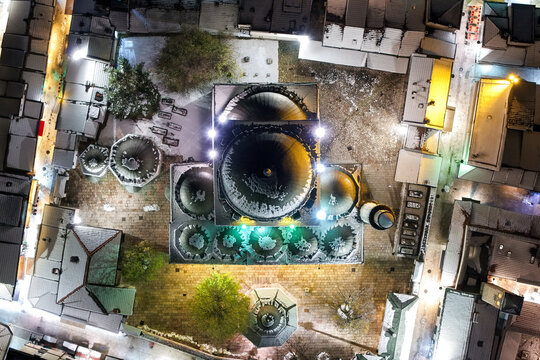 Aerial view of Gazi Husrev-beg Mosque glows warmly amid the cool, snow-dusted rooftops and narrow streets, Sarajevo, Federation of Bosnia and Herzegovina, Bosnia and Herzegovina.