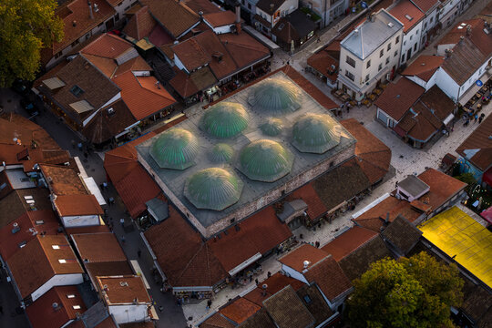 Aerial view of the Gazi Husrev-beg Bezistan's domes gleaming softly under the sun, surrounded by a tapestry of terracotta roofs, Sarajevo, Federation of Bosnia and Herzegovina, Bosnia and Herzegovina.