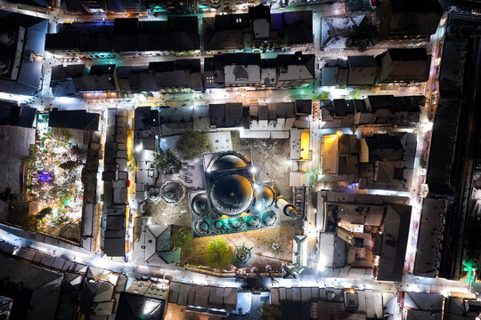 Aerial view of illuminated Gazi Husrev-beg Mosque nestled amidst snow-dusted rooftops, a mesmerizing winter scene, Sarajevo, Federation of Bosnia and Herzegovina, Bosnia and Herzegovina.