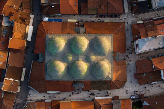 Aerial view of the Gazi Husrev-beg Mosque's domes glisten under the sunlight, surrounded by the city's terracotta rooftops, Sarajevo, Federation of Bosnia and Herzegovina, Bosnia and Herzegovina.