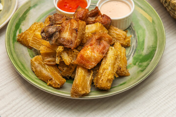 Delicious fried yuca in large wedges with smoky chipotle mayonnaise and lemon for dipping