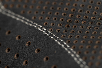 perforated natural leather of a dark shade for the manufacture of shoes, close up
