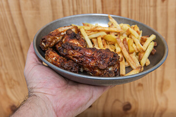 Crispy Southern-style fried chicken with rosemary and garlic baked potato wedges, served on a rustic wooden board with homemade barbecue sauce