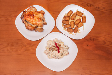 Classic set menu featuring half a roast chicken with golden, crispy skin, accompanied by four creamy Iberian ham croquettes and a side green salad