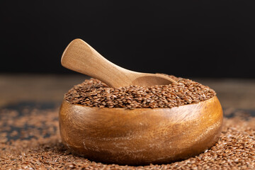 flax seeds in a wooden bowl, a round wooden bowl completely filled with flax seeds, which can be...