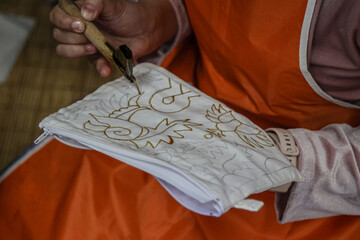 The process of batik making with wax on a cloth.
