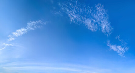 A large white cirrus clouds on a blue background. Detailed steam with cottony ends. Harsh midday...
