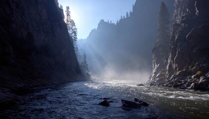 Dark canyon river with morning mist and sunlight shining through