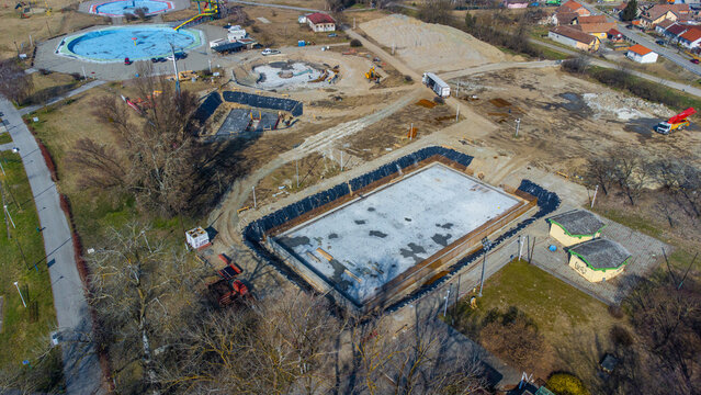 Aerial view of geometric swimming pools under construction, a symphony of raw materials and emerging forms against the backdrop of the park, Osijek, Osijek-Baranja County, Croatia.