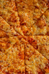 Sliced Pizza with Mozzarella cheese, Tomatoes and Spices. Italian pizza. Pizza Margherita or Margarita on wooden background