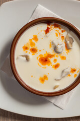 Traditional Bosnian dumplings — klepe. The dish served with a yoghurt sauce and spices on a wooden table