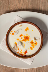 Traditional Bosnian dumplings — klepe. The dish served with a yoghurt sauce and spices on a wooden table