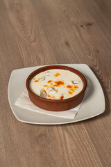 Traditional Bosnian dumplings — klepe. The dish served with a yoghurt sauce and spices on a wooden table