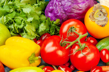 Vibrant close-up of vine-ripened tomatoes, red cabbage, yellow bell pepper, and persimmon