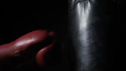 Boxer with a red glove punching a heavy bag - Powered by Adobe