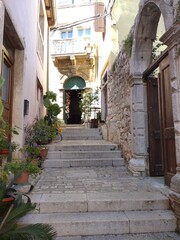 Old narrow street stairs with open door in Rovinj Croatia
