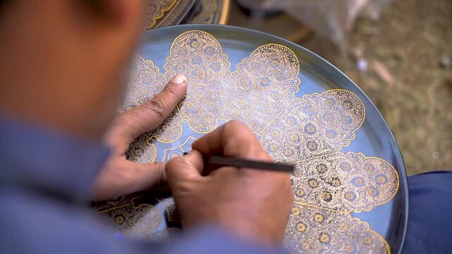 Slow-motion shot of Pakistani artist working on woods