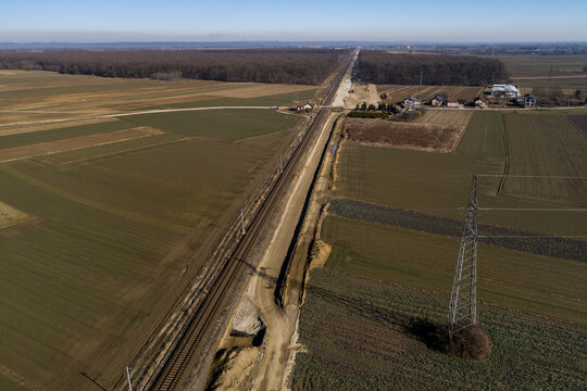 Aerial view of the railroad tracks slicing through the landscape near the forest and fields, a testament to progress and connectivity, Koprivnica, Koprivnica-Krizevci County, Croatia.