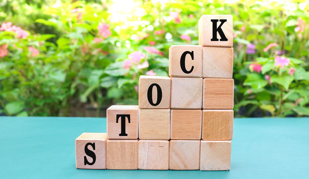STOCK letters on wood block cubes on table with nature background. Stock symbols. Concept word Stock on beautiful wooden blocks - Powered by Adobe