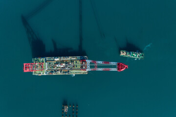 Aerial view of the Peljesac Bridge section being transported, its red and white support contrasting with the deep blue sea, Komarna, Dubrovnik-Neretva County, Croatia.