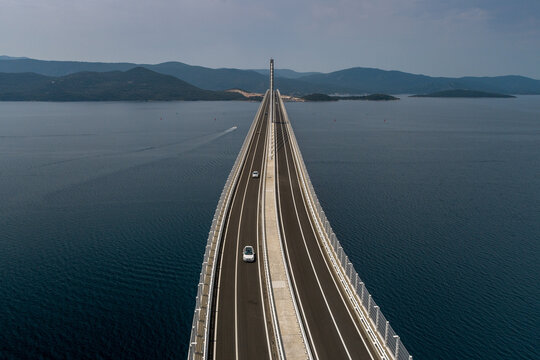 Aerial view of the Peljesac Bridge stretches boldly over the deep blue waters, connecting distant shores under a vast sky, Komarna, Dubrovnik-Neretva County, Croatia.