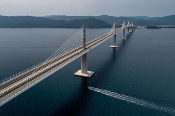 Aerial view of the sleek, modern Peljesac Bridge stretching across the azure waters, connecting mainland Croatia with the Peljesac Peninsula, Komarna, Dubrovnik-Neretva County, Croatia.