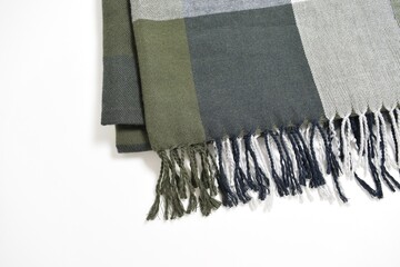 Folded multicolored scarf in a large checkered pattern with tassels on a white background