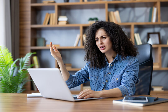 Frustrated woman experiencing technical difficulties with her laptop, feeling stressed and confused while working from home or in an office environment