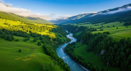Obraz premium Aerial view of a winding river through a lush green valley landscape