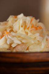 Fresh homemade sauerkraut or fermented cabbage with carrots, closeup. Vertical orientation.