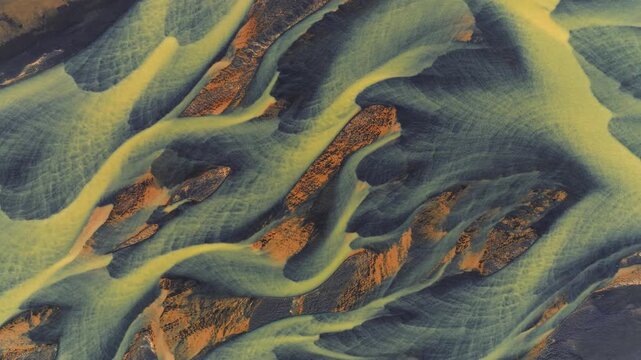 Aerial view of a braided river system contrasting yellow water with dark sediments, creating a stunning natural pattern, Reykjanes, Grindavikurbaer, Iceland.