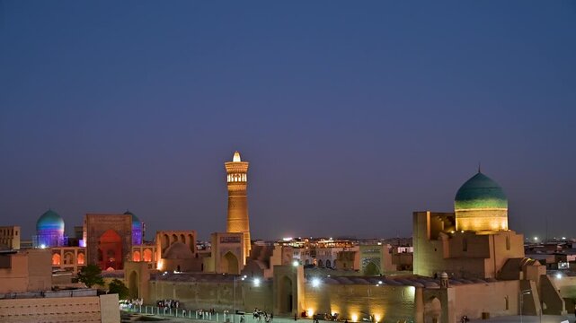A peaceful blue hour view over Bukhara, Uzbekistan, capturing rooftops, traditional clay buildings, and distant minarets under soft twilight tones. The calm evening atmosphere reflects the character o