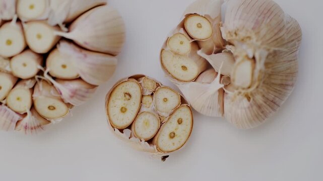 Close-up of sliced garlic bulbs on a white surface