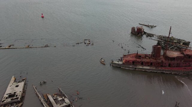 flying right view of decaying boats in Staten Island Boat Graveyard