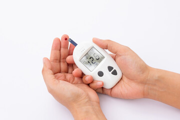 Fototapeta premium Woman's hands checking diabetes and hyperglycemia with digital blood sugar meter. Healthcare and medical concept 